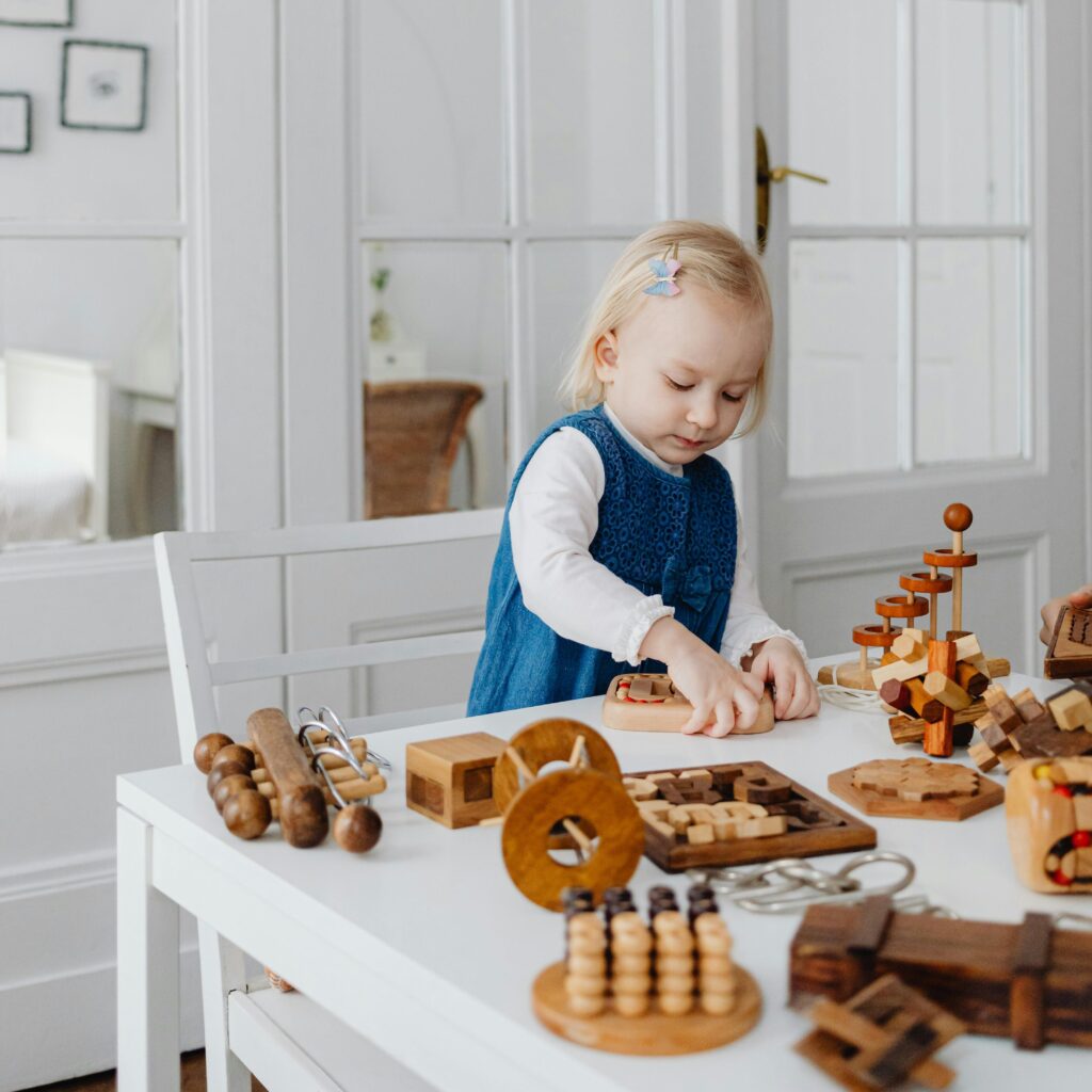 Young girl engaging creatively with wooden educational toys at home.