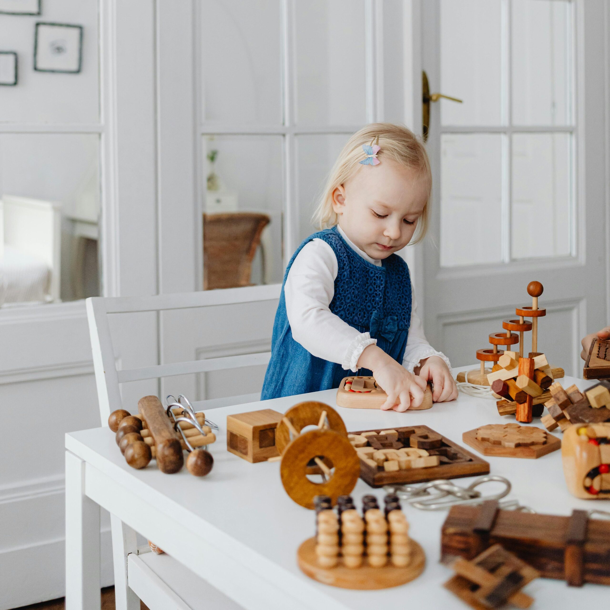 Young girl engaging creatively with wooden educational toys at home.